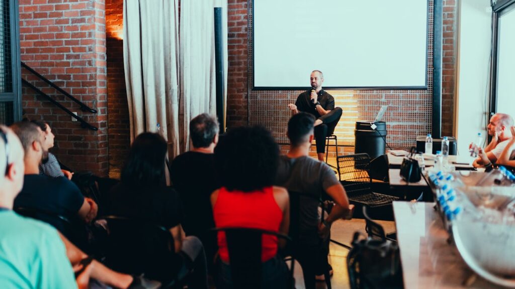 pexels-photo-3321791 A dynamic seminar with a speaker engaging a diverse audience in a modern indoor setting.